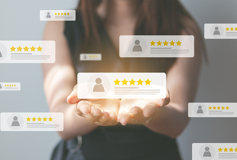 A person s hand holding a tablet displaying multiple star ratings and user reviews, symbolizing customer satisfaction or product evaluation.